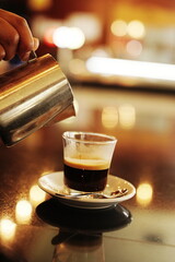 Dive into the delicious aroma of coffee with this captivating image of a waiter filling a cup...