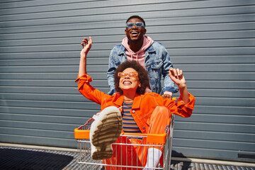 Cheerful young african american best friends in sunglasses and bright outfits having fun with...