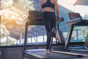 Fit young woman workout jogging in machine treadmill at fitness gym. Selected focus