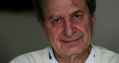Hopeful wrinkled senior man face smiling at camera portrait