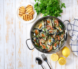 Tasty seafood in white sauce on a metal pan, copy space for text.