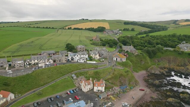 Aerial drone video of the small harbour village St. Abbs in Berwickshire, Scotland