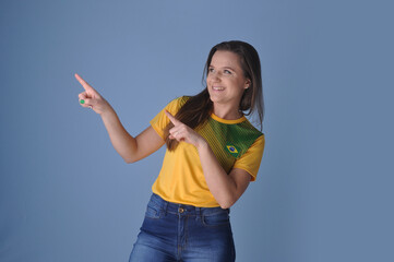 torcedora sorridente com camisa do brasil apontando para anúncio ou promoção, brasil no esporte...