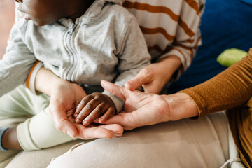 Mature women holding hand of their black adopted child