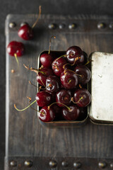 Fresh organic cherries in a tin box on a dark background. Top view - 622676108