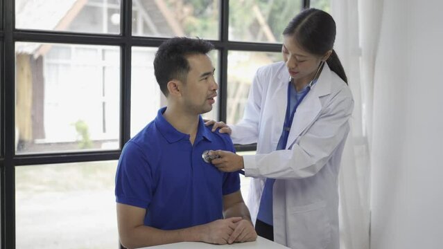 Doctor checking patient's respiratory rate or pulse rate by using stethoscope Asian man patient are checked up his health while a woman doctor use a stethoscope to hear heart rate.