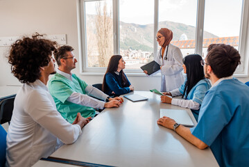 Medical team of doctors and nurse interacting at a meeting in conference room.