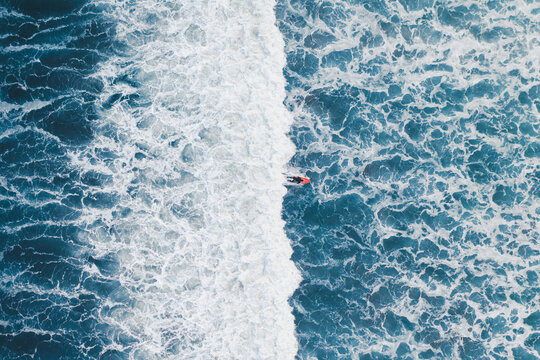 Aerial view of a surfer on a wave in Famara beach, Lanzarote, Spain.