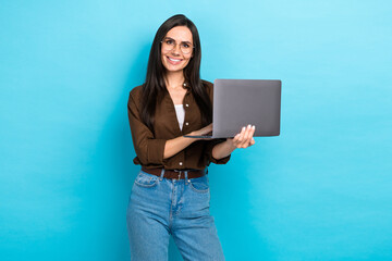 Photo of cute cheerful lady wear brown shirt spectacles working modern gadget isolated blue color background