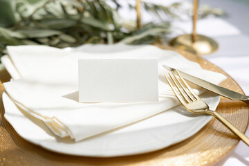 Name card mockup on plate with gold cutlery on olive branch background