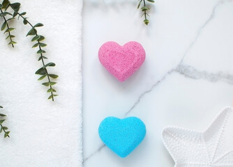 Natural cosmetics. Blue, pink heart-shaped bath bombs on marble background. Handmade colored bombs. Spa at home is place to copy