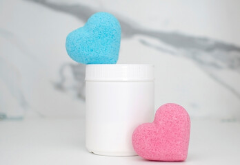 Natural cosmetics. Blue, pink heart-shaped bath bombs on marble background. Handmade colored bombs....