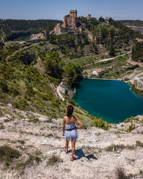 Aerial view of a woman in Alarcon, a medieval town with castle on top along the Rio Jucar river in Cuenca, Spain.