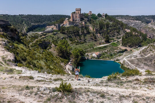 Aerial view of a woman in Alarcon, a medieval town with castle on top along the Rio Jucar river in Cuenca, Spain.
