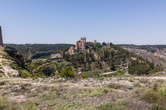 Aerial view of a woman in Alarcon, a medieval town with castle on top along the Rio Jucar river in Cuenca, Spain.