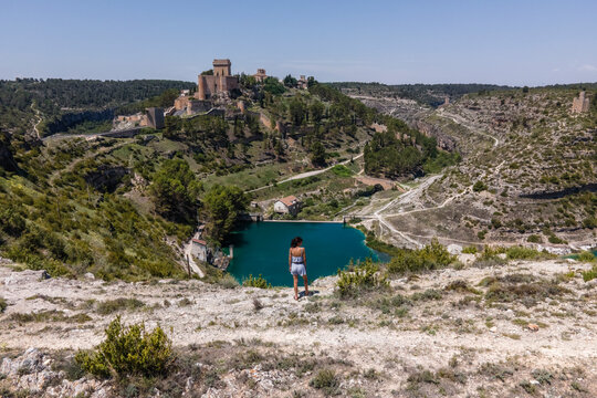 Aerial view of a woman in Alarcon, a medieval town with castle on top along the Rio Jucar river in Cuenca, Spain.