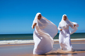 Fototapeta na wymiar A group of young muslim women wearing headscarves having fun together at the beach