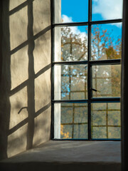 Close-up of a lattice window.  Shadows on wall. Sunny autumn day.