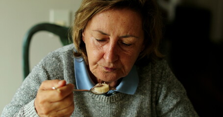 Senior woman eating breakfast older person eats cereal with milk