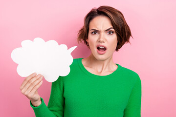 Photo of speechless stupor girl dressed green sweater holding speaking cloud empty space isolated pink color background