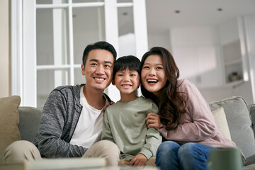 young asian family with one kid having a good time at home