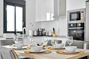 Dinnerware served on dining table in modern kitchen