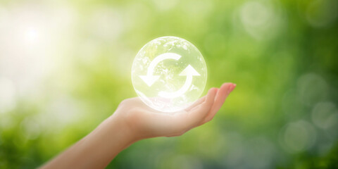 Hand holding earth with reusing logo inside on blurred natural background, sustainable concept to promote resource conservation and environmentally conscious practices, sustainable world environment