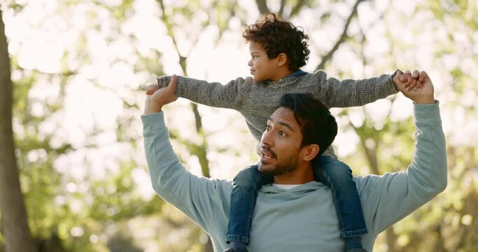 Nature, walk and father with his child on his shoulder in an outdoor park for fresh air. Talking, bonding and young man carrying his boy kid by the trees in a green garden together on a weekend trip.