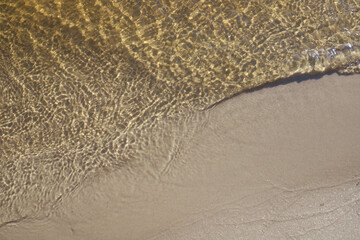 ripples of different patterns on the water surface of a sandy golden color. texture and background. for flyers banners screensavers and more