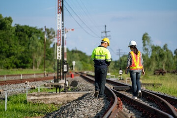 Architects and engineers wear safety suits and helmets to work. Walk to inspect the tracks to plan for maintenance.