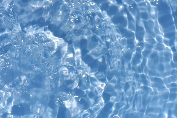 Blue water with ripples on the surface. Defocus blurred transparent blue colored clear calm water surface texture with splashes and bubbles. Water waves with shining pattern texture background.