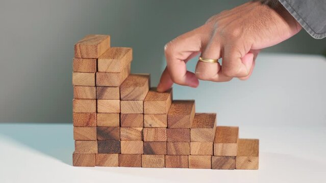 Business two finger symbol walking up on wood blocks shape staircase to climb up career ladder step up stair growth success, prevent collapse or crash concept