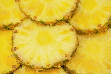 Pineapple juicy yellow slices as a background.