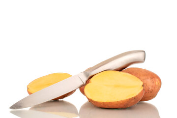 Two whole pink, raw potatoes and halves with a metal knife, macro, isolated on white background.