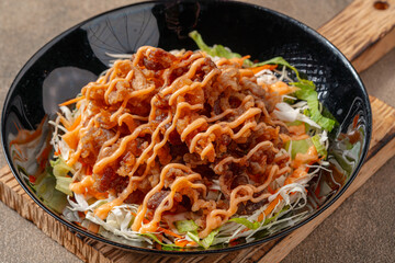 Crispy beef fillet pieces with mayonnaise plating on a black plate