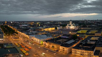 Helsinki Cathedral and Market Square by lit government buildings at dawn