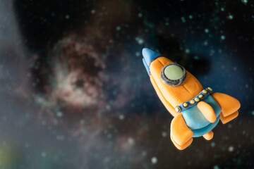 A spaceship made of plasticine in space, children's creativity, fantasies. Bright and cosmic...