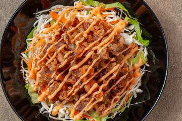 Crispy beef fillet pieces with mayonnaise plating on a black plate