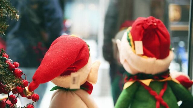 Christmas puppets in a shop showcase with city life outside, slow motion