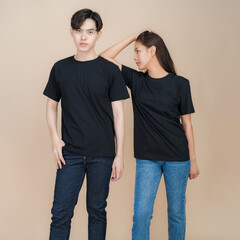 An image of a male and female fashion model standing in black t-shirt and jeans standing in studio on beige background