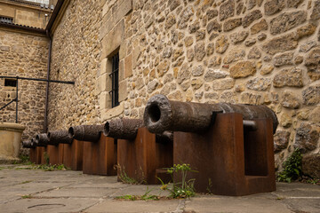 Antique cannon artillery defensive weapon on wall of cultural historic fort building Castillo de la Mota on Mount Urguell in front of bahia de la concha Donosita-San Sebastian Spain. 