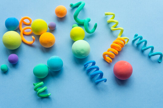 Colorful abstract figures made of plasticine, spirals and balls of different sizes. Funny illustration for the background of children's holidays.