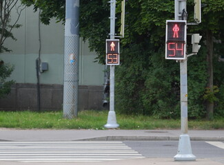 The traffic lights at the pedestrian crossing are triggered with a difference of one second
