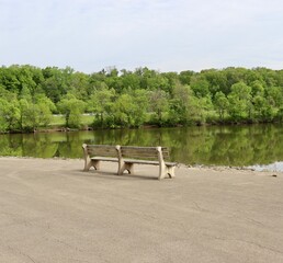 The empty park bench at the lake on a sunny day.