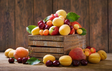 fresh fruits in a wooden box on wooden background