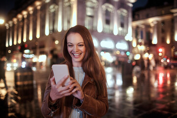 Young woman using a smart phone while walking in the city london