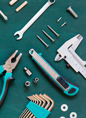 Set of professional tools for renovation or home repairs on the green wooden background.