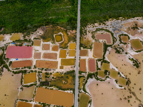 Aerial view of a road crossing the Laguna Rosada, the pink salt lakes in Dzemul Municipality, Yucatan, Mexico.