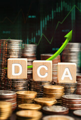 DCA word on a wooden cube on coins stack. Dollar cost averaging investment strategy, Saving stock monthly, quarterly basis. spreading out your stock idea, fund purchases, business concept. vertical