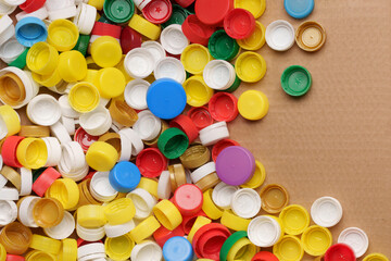 Fototapeta na wymiar Colorful bottle caps background cardboard box. Used PET recycling plastic bottle cap plastic lids. Garbage PET waste recycling bottle cap sorting waste plastic garbage collection. Recyclable materials
